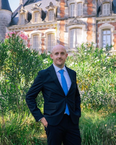 Erwann in a suit in front of a château